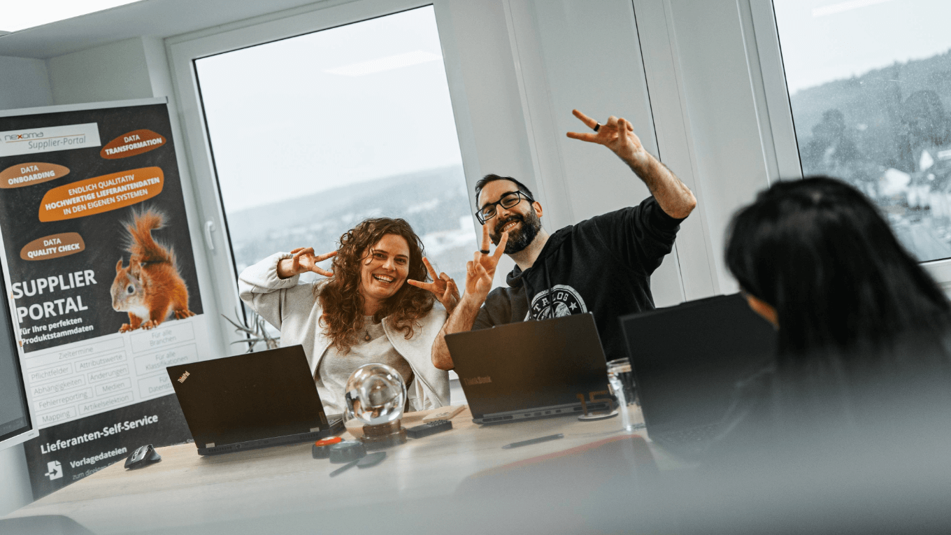 zwei nexoma Mitarbeiter zeigen ein Peace und freuen sich über ihr Jobs